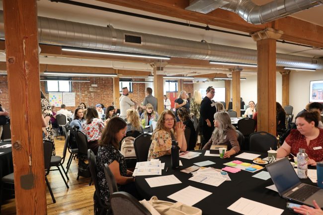 a group of people talking around a table