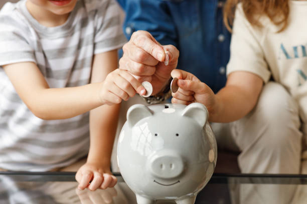 grandfather and grandchildren saving money stock photo